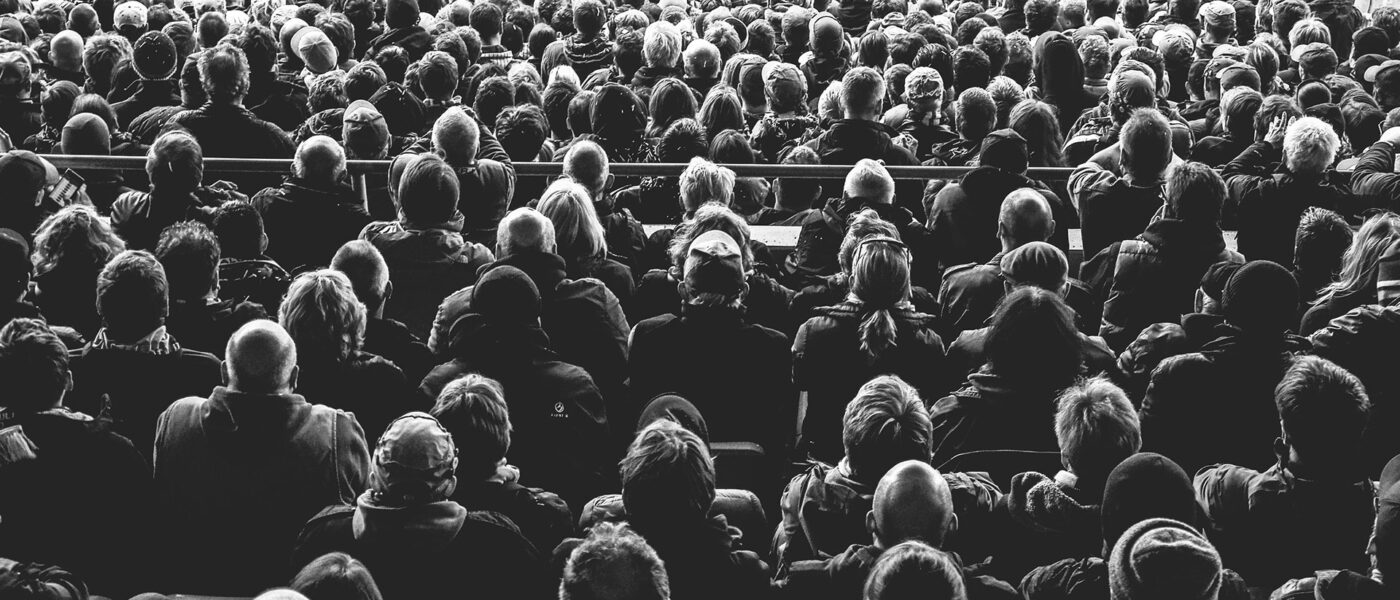 A crowd of people seated and motionless.